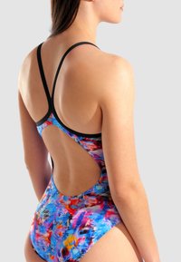 Il costume da bagno intero colorato presenta un motivo astratto in blu, rosso e giallo. Ha larghe spalline nere e un design con schiena scoperta.