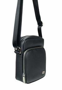 Sac à bandoulière noir en matériau synthétique texturé avec une sangle ajustable, une fermeture éclair et un logo discret à l'avant.