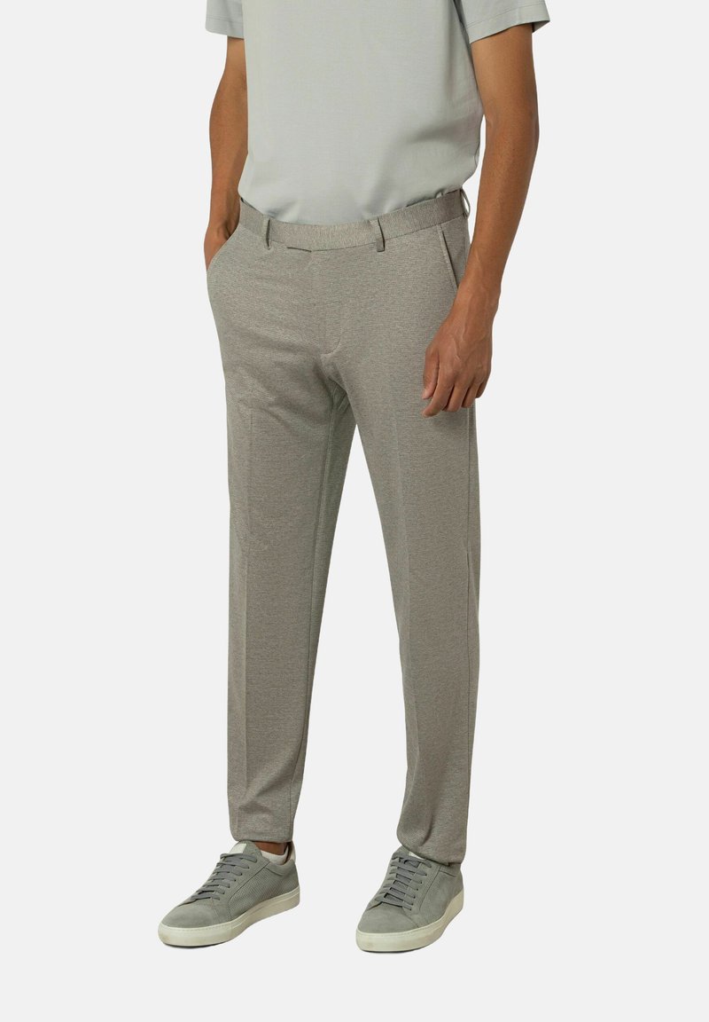 Lichtgrijze slim-fit broek met een gestructureerd patroon, met een tailleband, zijzakken en gecombineerd met grijze sneakers.