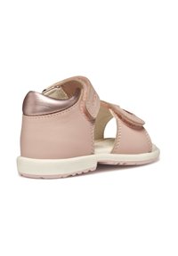 Sandalo in pelle rosa con una texture morbida, lati aperti e un accento in metallo color oro rosa sul tacco. Presenta una fascia regolabile per una vestibilità sicura.