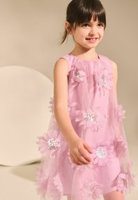 Vestido sin mangas rosa con una superposición de tul en capas, decorado con embellishments florales y acentos de lentejuelas, que presenta una textura suave y translúcida.