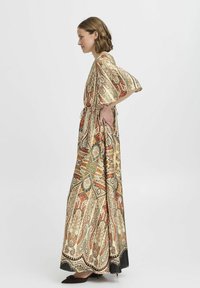 Maxiklänning i silkesliknande tyg med intrikata paisley- och blommönster i varma färger. Korta utsvängda ärmar och en elastisk midjedetalj.