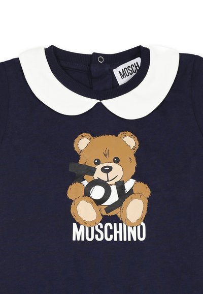 Camicia di cotone blu navy con colletto bianco a forma di Peter Pan, grafica di un orsetto cartoon e testo "Toy Moschino" in bianco.