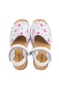 White sandals with a patterned upper featuring pink and blue designs of balloons and clouds, leather insole, and adjustable ankle strap.