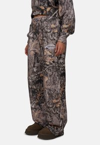 Camo-patroonbroek van zachte stof, met een relaxed fit, elastische tailleband en zijzakken. Verfraaid met logo-details.