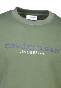 Grön sweatshirt med rund halsringning, prydd med "COPENHAGEN" i marinblått och "LINDBERGH" i vitt. Mjuk tygkvalitet med avslappnad passform.