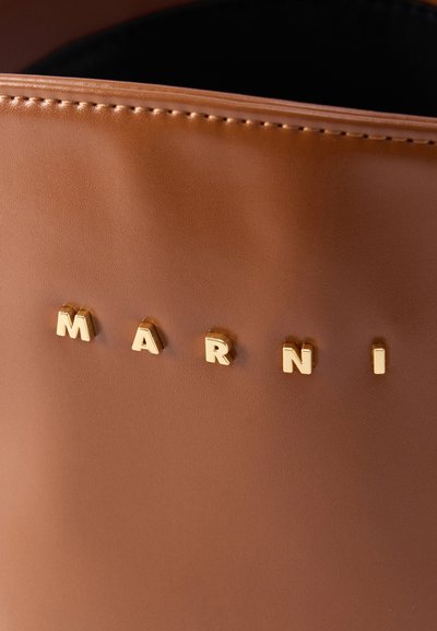 Καφέ δερμάτινο αντικείμενο με χρυσά γράμματα που σχηματίζουν τη λέξη «MARNI» και ραμμένο περίγραμμα ορατό στο πάνω μέρος.