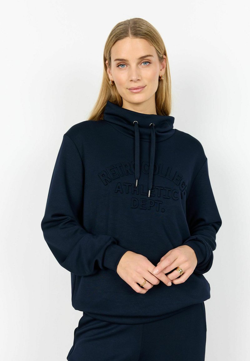 Hanorac bleumarin cu guler înalt, având textul „RETRO COLLEGE ATHLETIC DEPT.” embossat pe față și șnururi pentru ajustare.