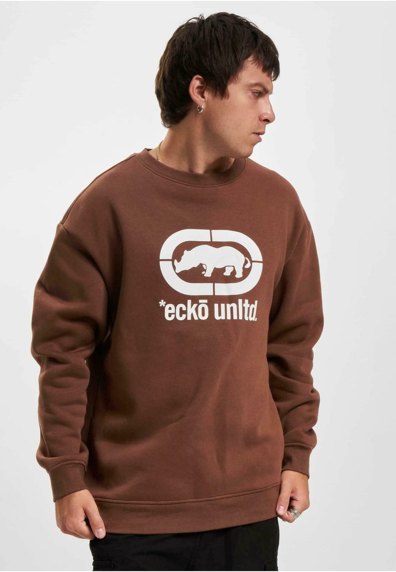 Sweatshirt en coton marron avec un col et des poignets côtelés. Présente un grand motif blanc d'un rhinocéros et le texte "*eckō unltd."