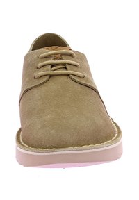 Scarpe in suede beige con lacci, caratterizzate da una punta arrotondata, dettagli cuciti e una leggera suola in gomma. Superficie testurizzata con elementi di design minimali.