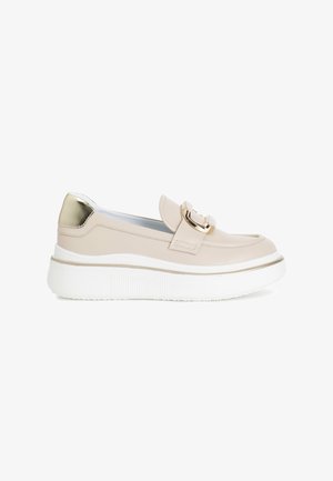 Beige leather slip-on shoe with a gold accent and decorative buckle, featuring a white platform sole with textured detailing.
