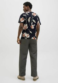 Trumpas rankovėmis tamsiai mėlynas marškinis su gėlių raštu kremine, raudona ir žalia spalvomis. Derinamas su pilkomis kelnėmis ir šviesių spalvų bateliais.