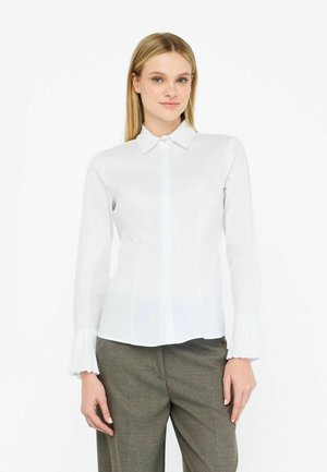 Camicia bianca a maniche lunghe con colletto, polsini plissettati e chiusura a bottoni. Tessuto morbido con una vestibilità sartoriale.