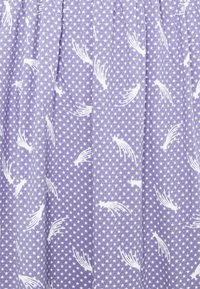 Lavendelfärgad tyg med ett tätt mönster av små vita stjärnor och spridda vita fallande stjärnor med svansar.