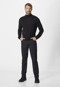 Black turtleneck sweater with long sleeves, paired with dark gray trousers and black shoes. The outfit features a slim fit and smooth texture.