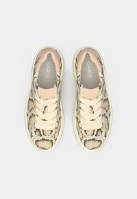 Αθλητικά παπούτσια με μπεζ και μαύρο μοτίβο φίδι, με απαλό δερμάτινο σχέδιο, στρογγυλή μύτη και κορδόνια ανοιχτού χρώματος.