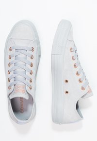 Sneaker in suede grigio chiaro con design a bassa top, caratterizzate da occhielli in oro rosa, lacci abbinati e suola in gomma testurizzata. Logo sulla linguetta.