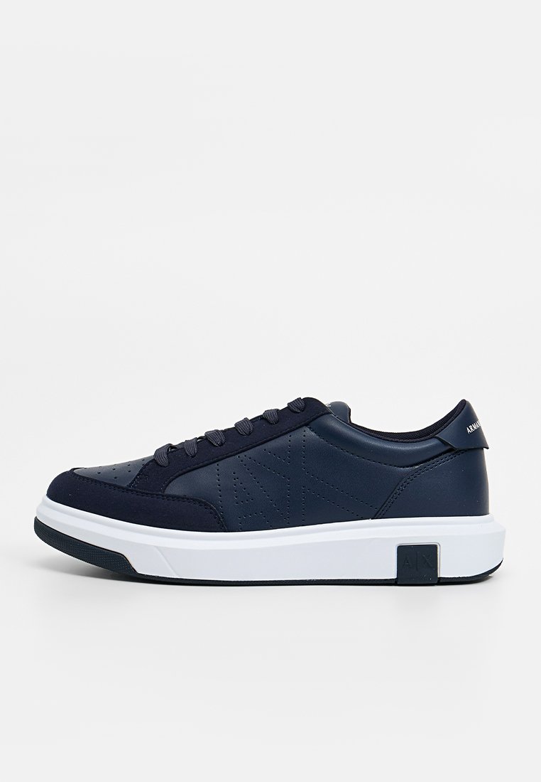 Sneaker blu navy con tomaia in pelle liscia, punta rotonda e suola in gomma bianca. Presentano dettagli perforati e accento del logo sul tallone.