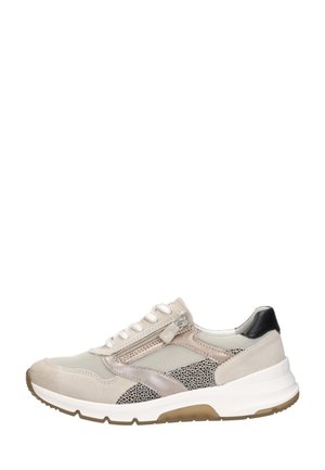 Beige lage sneaker met witte veters, zijrits, zwart gevlekte panelen, beige suède en een witte zool met lichtbruine profielaccenten.