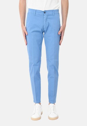 Pantaloni in cotone azzurro chiaro con vestibilità slim, dotati di tasche, chiusura con bottone e superficie liscia. Indossati con sneakers bianche.