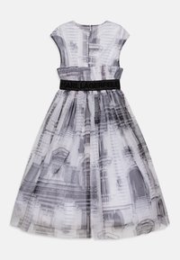 Robe en tissu translucide avec un imprimé architectural noir et blanc, taille cintrée avec une ceinture noire texturée, manches courtes.