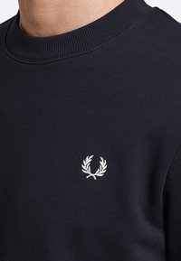 Felpa blu navy in cotone con collo a girocollo a coste, dotata di un logo ricamato bianco a foglie di alloro sul petto.