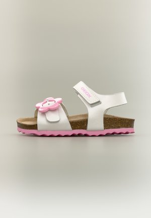 Hvid og pink børnesandal med korksål, pink blomst dekoration på forreste rem og justerbar ankelrem med "GEOX" label.