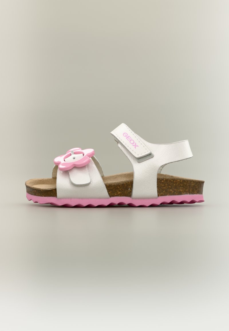 Παιδικό σανδάλι σε λευκό και ροζ με σόλα από φελλό, ροζ διακόσμηση λουλουδιού στο μπροστινό λουράκι και ρυθμιζόμενο λουράκι αστραγάλου με ετικέτα "GEOX".