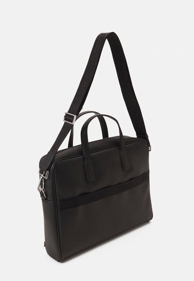 Sac à dos en cuir lisse de couleur noire, doté de deux poignées supérieures, d'une bandoulière amovible et d'un accent de marque à l'avant.
