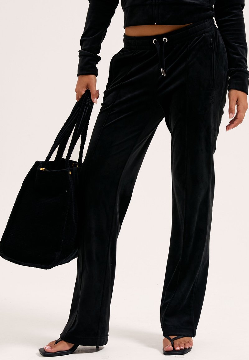 Svarta velourbyxor med avslappnad passform, med elastisk midja, dragsko och sidofickor, som matchas med en svart tote-väska.