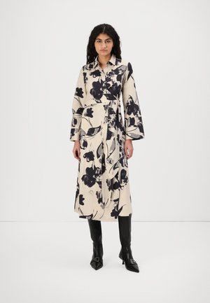 Floral-patterned wrap dress in cream with black and gray flowers, long sleeves, and a waist tie, paired with black knee-high pointed boots.