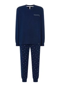 El conjunto de ropa de casa en color navy incluye una camiseta de manga larga con escote en V y un bolsillo en el pecho, además de pantalones con un patrón de estrellas. Tejido de algodón, corte relajado.