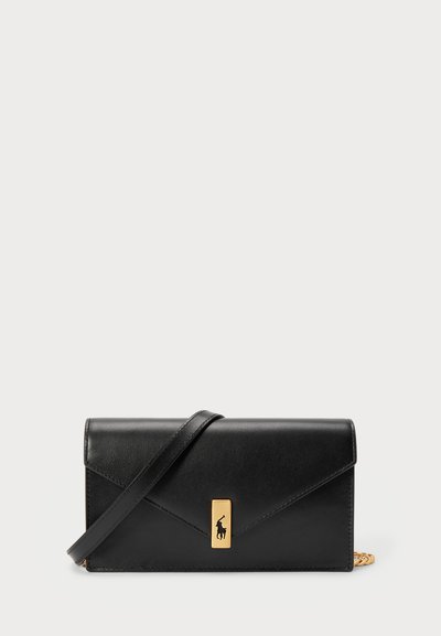 Portefeuille en cuir noir avec un rabat, matériel en or, mettant en avant un accent de logo. Inclut une sangle détachable pour le transport.