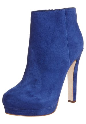 Botín de ante azul con tacón alto, suela con plataforma y puntera redondeada, con un delgado tacón de aguja y cremallera lateral.