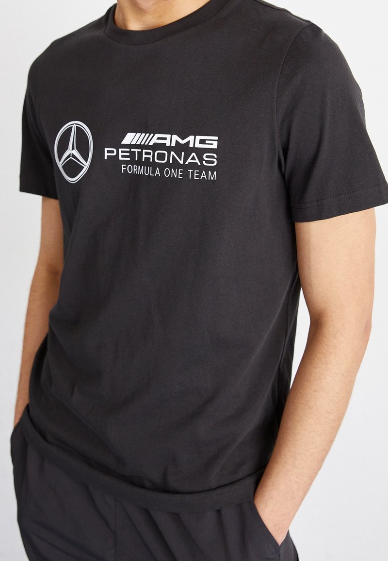 Czarna bawełniana koszulka z okrągłym dekoltem, ozdobiona białymi nadrukami: gwiazda Mercedes-Benz i "AMG PETRONAS Formula One Team."