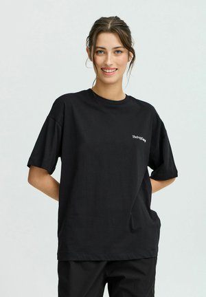 Black cotton t-shirt with a loose fit, crew neck, and short sleeves. Features a small white logo on the left chest area.
