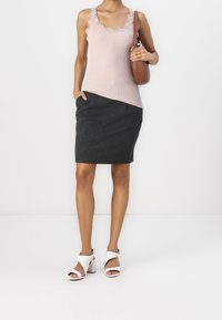 Světle růžový žebrovaný top bez rukávů s krajkovým lemem, šedý tužkový sukňový šat s kapsami a bílé sandály s blokovým podpatkem. Hnědá crossbody taška.