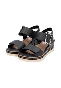 Sandales en cuir noir avec deux larges sangles, une boucle décorative, une semelle plateforme crème et des détails de surfilage contrastés.
