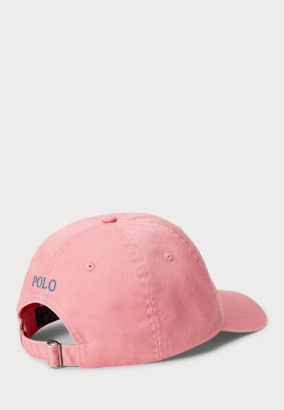 Boné de baseball em algodão rosa com faixa ajustável, apresentando "POLO" bordado em azul na parte da frente. Textura suave, aba curvada.