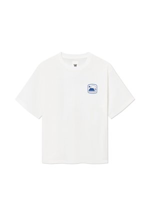 T-shirt blanc à manches courtes avec un petit patch bleu sur le thème de la météo sur le côté gauche de la poitrine montrant le soleil, un nuage et du texte.