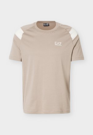 Beež lühikeste varrukatega t-särk, millel on valged õlaservad ja vasakul rinnal väike valge EA7 Emporio Armani logo.