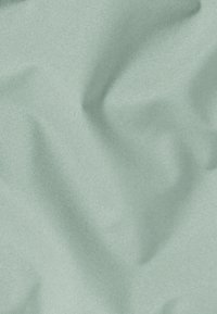 Weicher, strukturierter Stoff in einem hellen Minzgrün. Die Oberfläche wirkt leicht zerknittert und erzeugt ein sanft fließendes Aussehen.