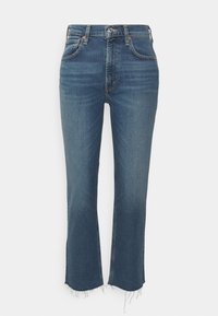 Jeans de mezclilla en azul oscuro con corte recto, ligero desvanecimiento y dobladillo deshilachado. Cuenta con cremallera en la bragueta y cinco bolsillos.