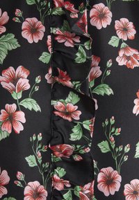 Tissu noir avec un motif floral de fleurs roses et rouges et de feuilles vertes, avec une couture froncée verticale au centre.