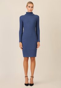 Abito aderente a collo alto in maglia a coste di colore blu navy, realizzato in morbido tessuto knit. Presenta maniche lunghe e un orlo fino al ginocchio.