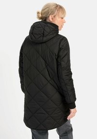 Schwarze gesteppte Daunenjacke mit Kapuze, diagonaler Naht und Rippbündchen. Mittellanges Design, glatte Textur und keine sichtbaren Hardware-Details.