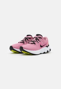 Scarpe da ginnastica rosa chiaro con tomaia in rete, lacci neri e intersuola bianca. Presentano una suola nera testurizzata con accenti verde neon.