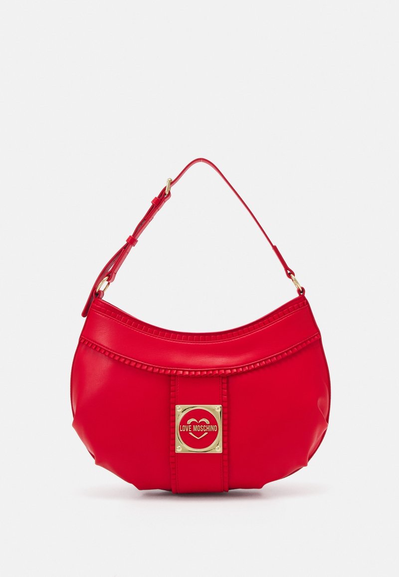 Sac à main rouge en matériau brillant avec une forme semi-circulaire. Comprend un accent logo doré et des détails cousus le long du bord supérieur.