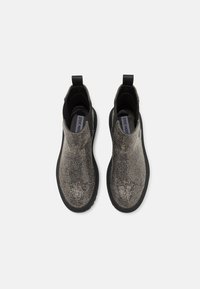 Bottines noires avec un motif argenté texturé, des panneaux latéraux élastiques et une languette de traction. Semelles en caoutchouc et design à bout rond.
