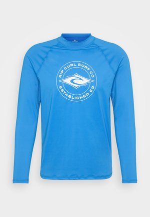 Ilgi piedurkņu saulessargs spilgti zilā krāsā, izgatavots no gludas, elastīgas auduma. Priekšpusē ir apļveida balta logo.